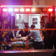 Emergency responders administer CPR to an unknown patient on a stretcher as law enforcement officials stand nearby at Baylor University Medical Center in Dallas.